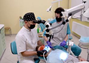 Врач стоматолог-ортопед Ключников Д. А. проводит лечение при помощи микроскопа
